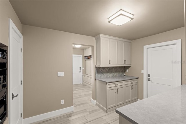 kitchen featuring decorative backsplash and white cabinetry