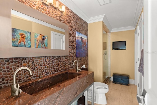 bathroom featuring a shower with shower door, toilet, and ornamental molding