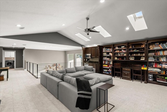 living room featuring washer / dryer, ceiling fan, lofted ceiling, and a textured ceiling