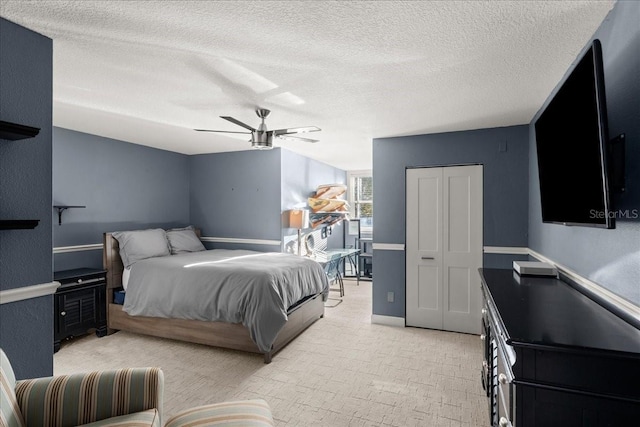 bedroom with ceiling fan, a textured ceiling, and a closet