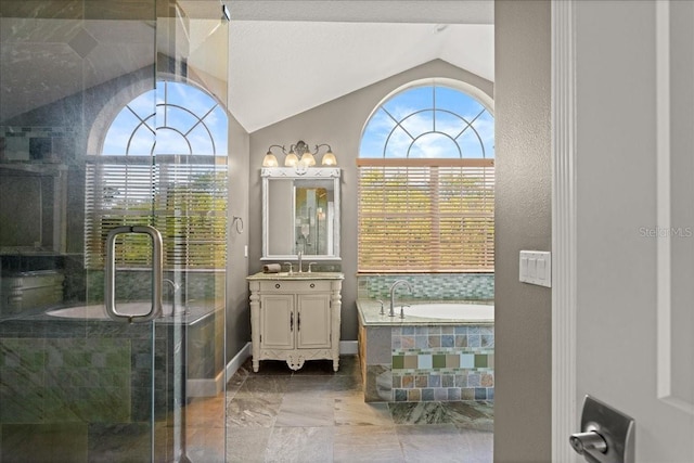 bathroom with independent shower and bath, lofted ceiling, and vanity