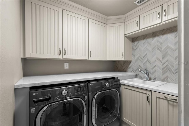 laundry area featuring washing machine and dryer, sink, and cabinets