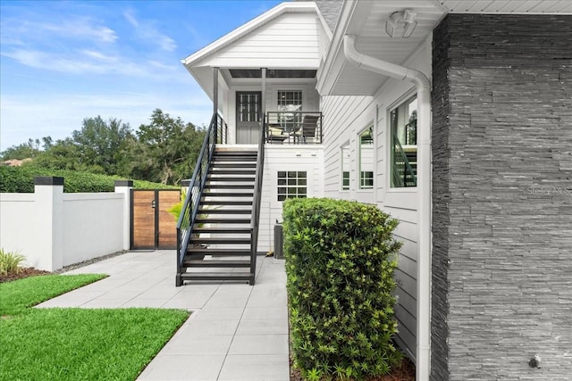 view of exterior entry with central AC unit and a patio