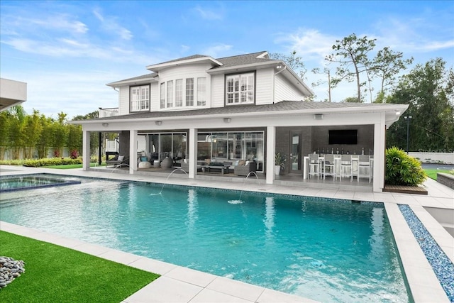 back of property featuring an outdoor bar, a fenced in pool, a patio, an outdoor living space, and pool water feature