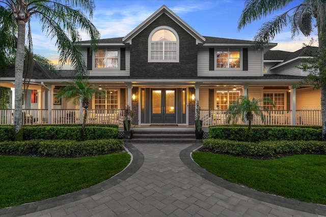 view of front of house with a yard and a porch