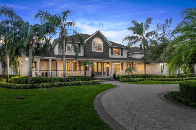 view of front of house featuring a lawn and covered porch