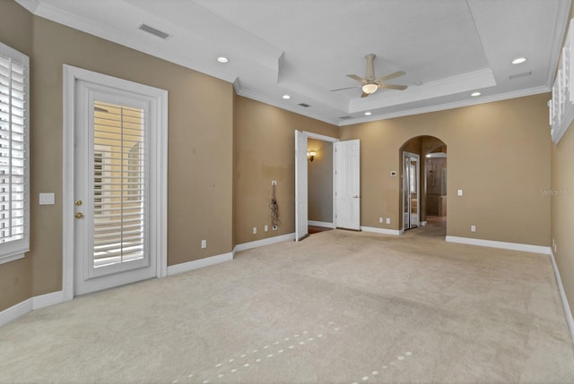 carpeted spare room featuring ceiling fan, crown molding, and a raised ceiling