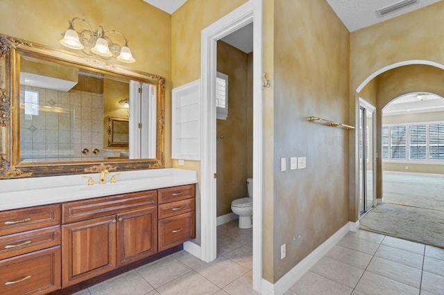 bathroom with toilet, tile patterned floors, and vanity