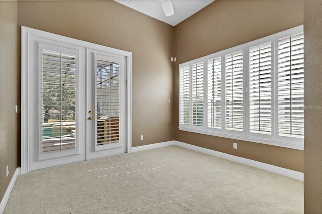 unfurnished room featuring ceiling fan, light colored carpet, and french doors