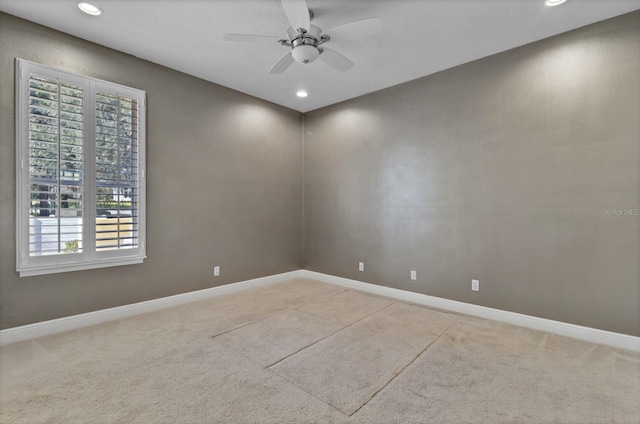 spare room featuring ceiling fan, a healthy amount of sunlight, and light colored carpet