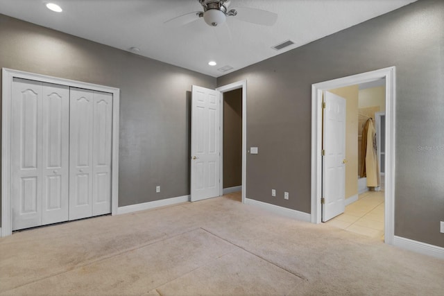 unfurnished bedroom featuring light carpet, ceiling fan, and a closet