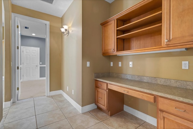 kitchen with built in desk and light tile patterned flooring