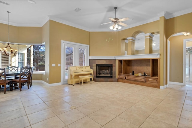 living room with crown molding, light tile patterned floors, plenty of natural light, and ceiling fan with notable chandelier