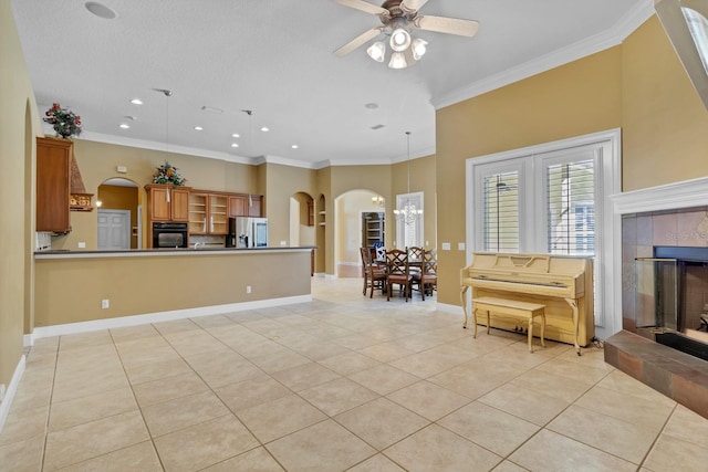 kitchen featuring a tiled fireplace, stainless steel fridge, light tile patterned flooring, and oven