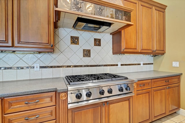 kitchen featuring exhaust hood, light tile patterned floors, stainless steel gas cooktop, and tasteful backsplash