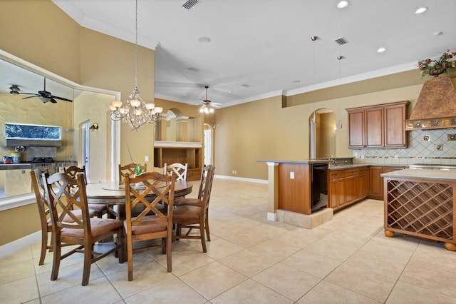 dining space with ceiling fan with notable chandelier, light tile patterned floors, ornamental molding, and sink