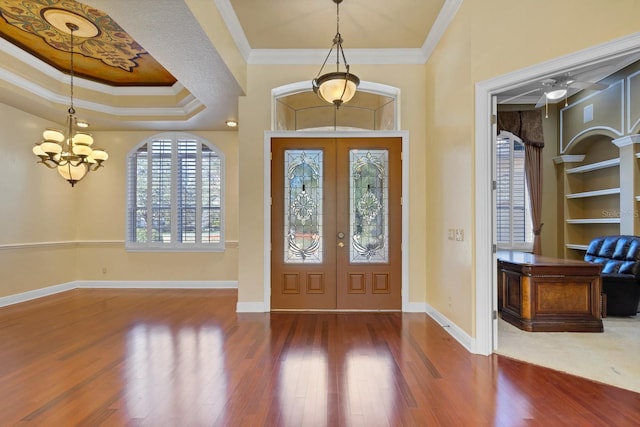 entryway with hardwood / wood-style flooring, crown molding, french doors, and a tray ceiling