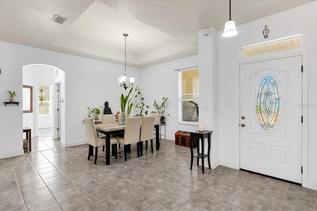 dining space featuring a chandelier and a tray ceiling