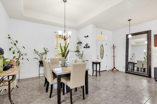 dining room featuring a notable chandelier and a tray ceiling