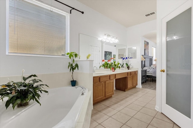 bathroom featuring vanity, a tub, and tile patterned floors