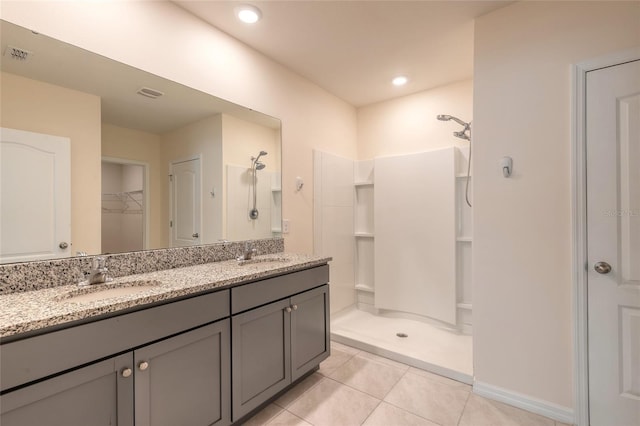 bathroom featuring a shower, vanity, and tile patterned flooring