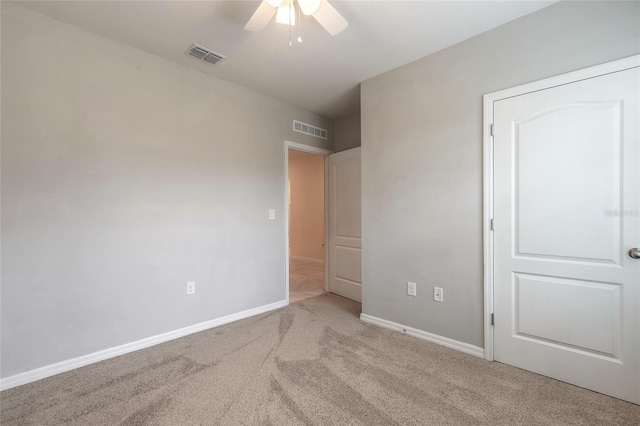 unfurnished bedroom with ceiling fan and light colored carpet