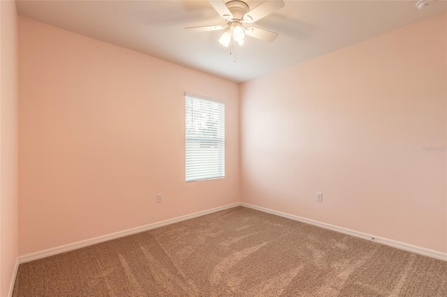 carpeted spare room featuring ceiling fan