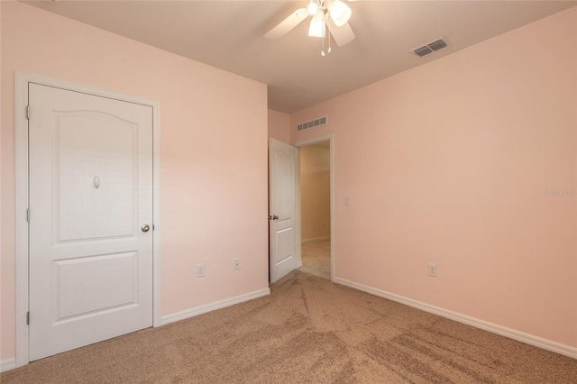 unfurnished bedroom featuring light carpet and ceiling fan