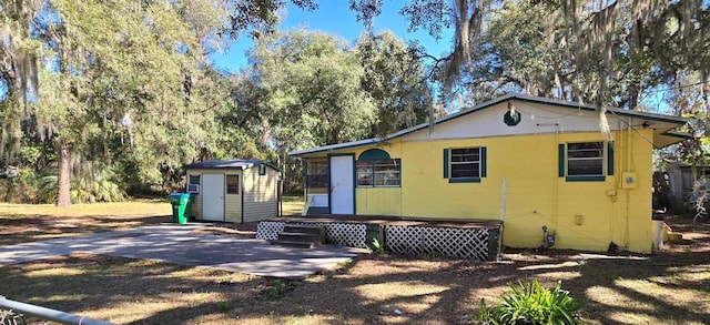 view of front of property featuring a shed and a patio