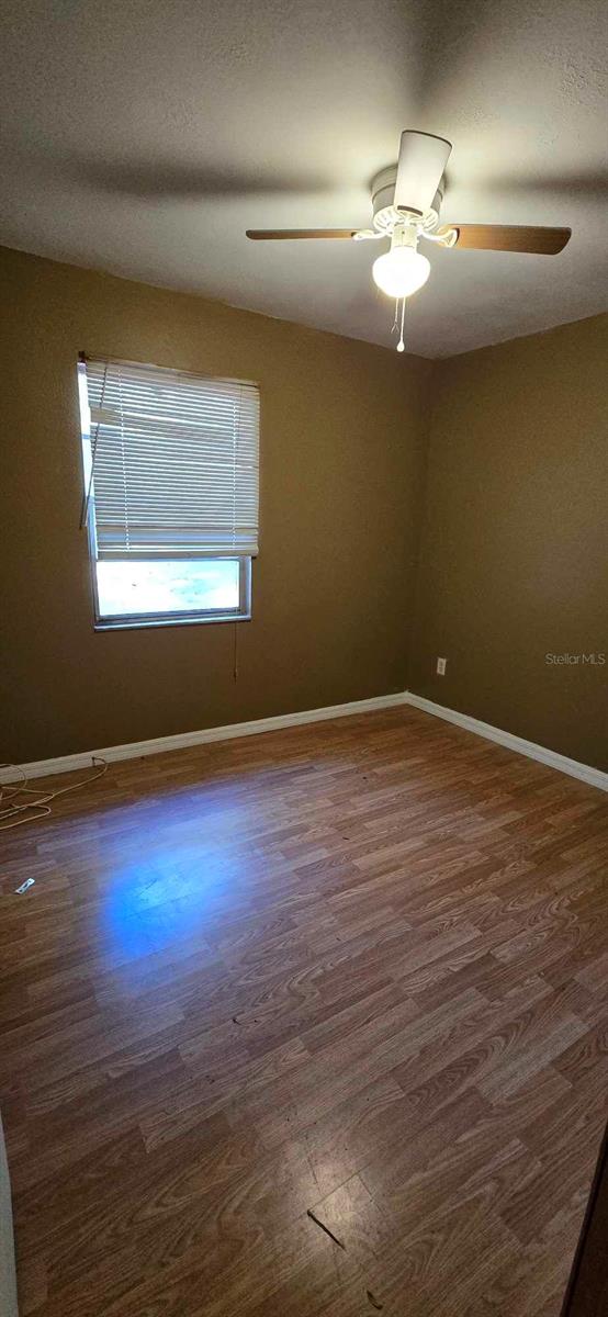 spare room with ceiling fan and dark wood-type flooring