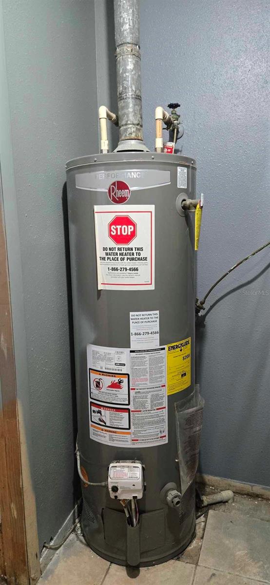 utility room featuring water heater