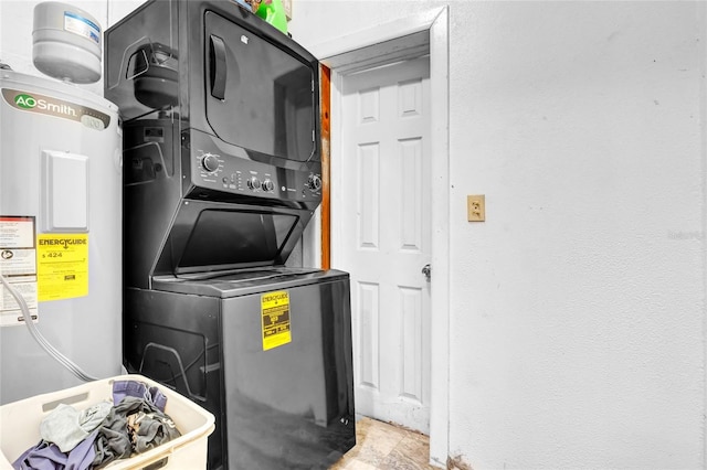 clothes washing area with electric water heater and stacked washer and dryer