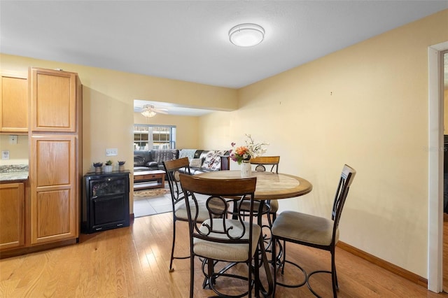 dining space with ceiling fan and light hardwood / wood-style flooring