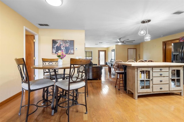 dining room with ceiling fan and light wood-type flooring