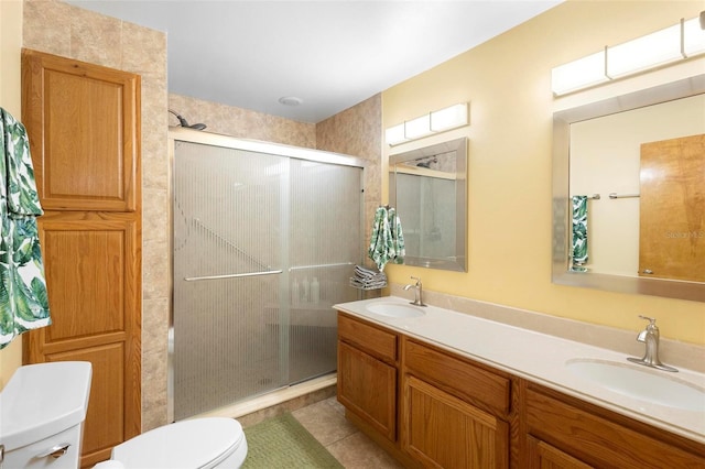 bathroom featuring toilet, tile patterned flooring, walk in shower, and vanity