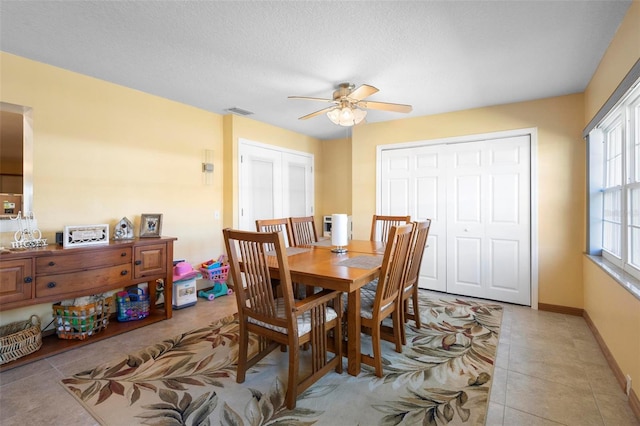 tiled dining area featuring ceiling fan and a textured ceiling