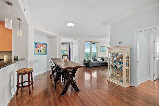 dining space with dark wood-type flooring and ornamental molding