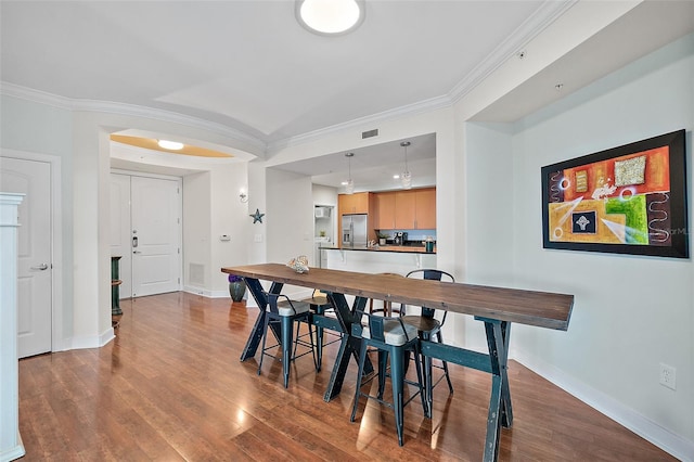 dining room featuring hardwood / wood-style floors and ornamental molding