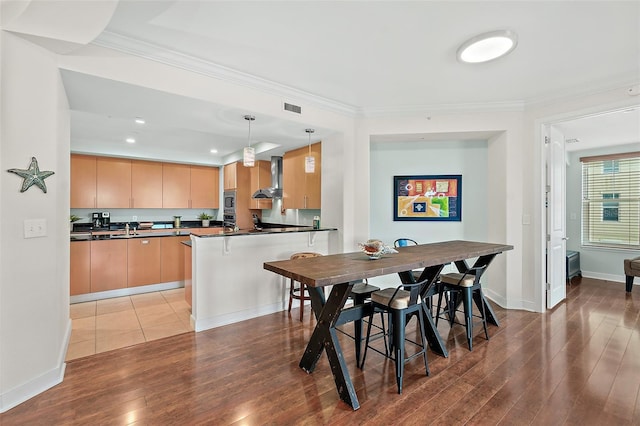 dining area featuring light wood-type flooring and crown molding