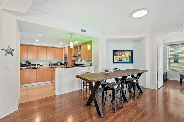 dining area featuring ornamental molding and light hardwood / wood-style floors