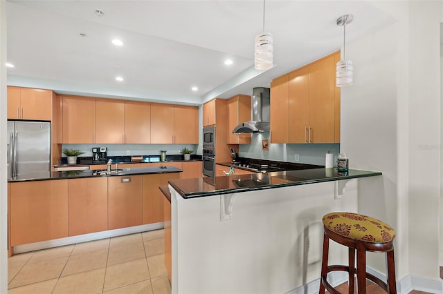 kitchen featuring kitchen peninsula, sink, hanging light fixtures, appliances with stainless steel finishes, and wall chimney exhaust hood