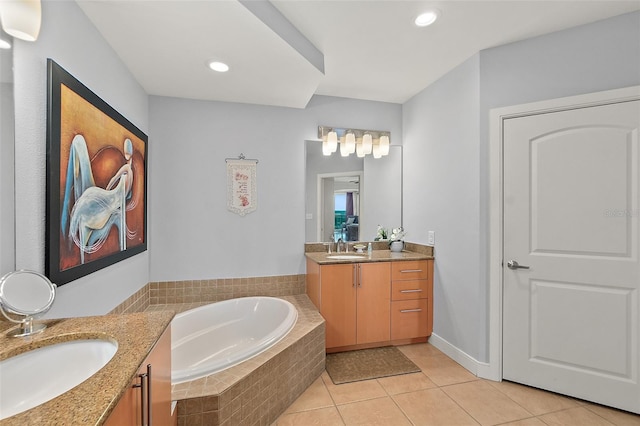 bathroom featuring vanity, tile patterned floors, and a relaxing tiled tub