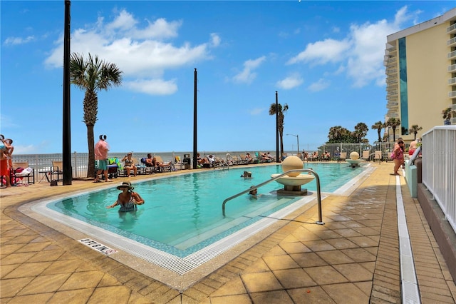 view of swimming pool with a water view and a patio