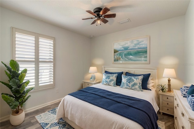 bedroom featuring ceiling fan, multiple windows, and dark hardwood / wood-style floors