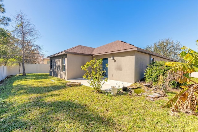 rear view of property featuring a patio area and a yard