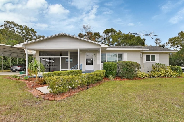 view of front of house with a front lawn, a sunroom, and a carport