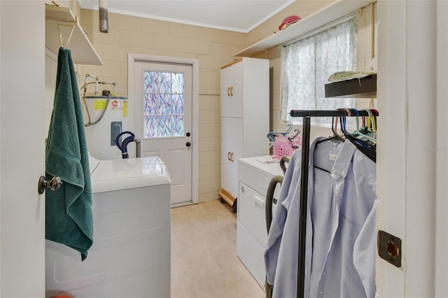 washroom featuring electric water heater, crown molding, and washing machine and clothes dryer