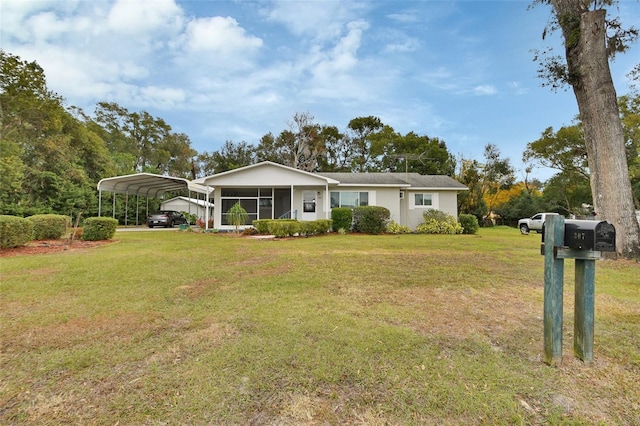 ranch-style home featuring a front lawn and a carport