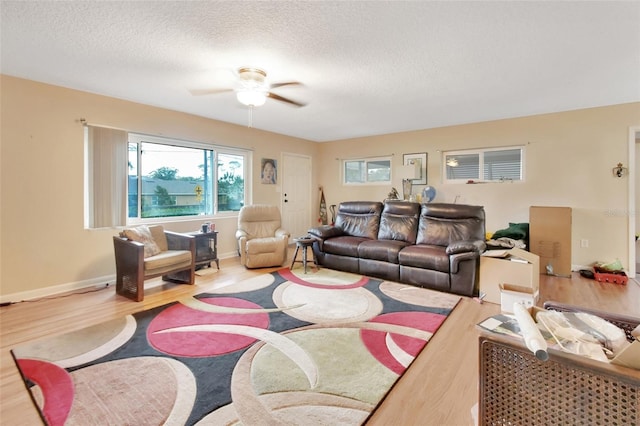 living room with ceiling fan, hardwood / wood-style floors, and a textured ceiling