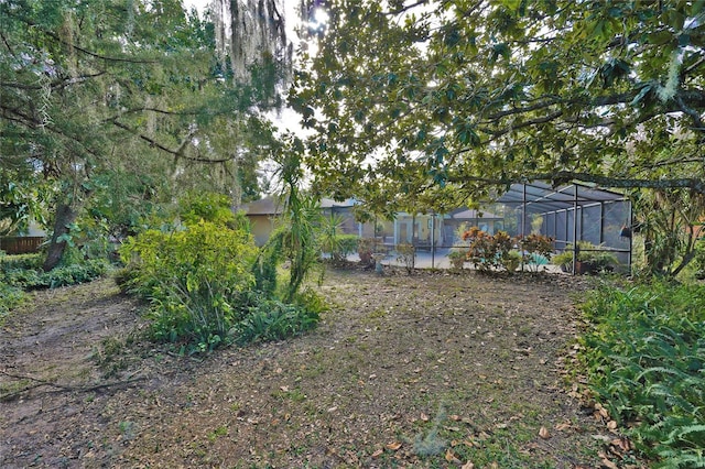 view of yard with a patio and glass enclosure